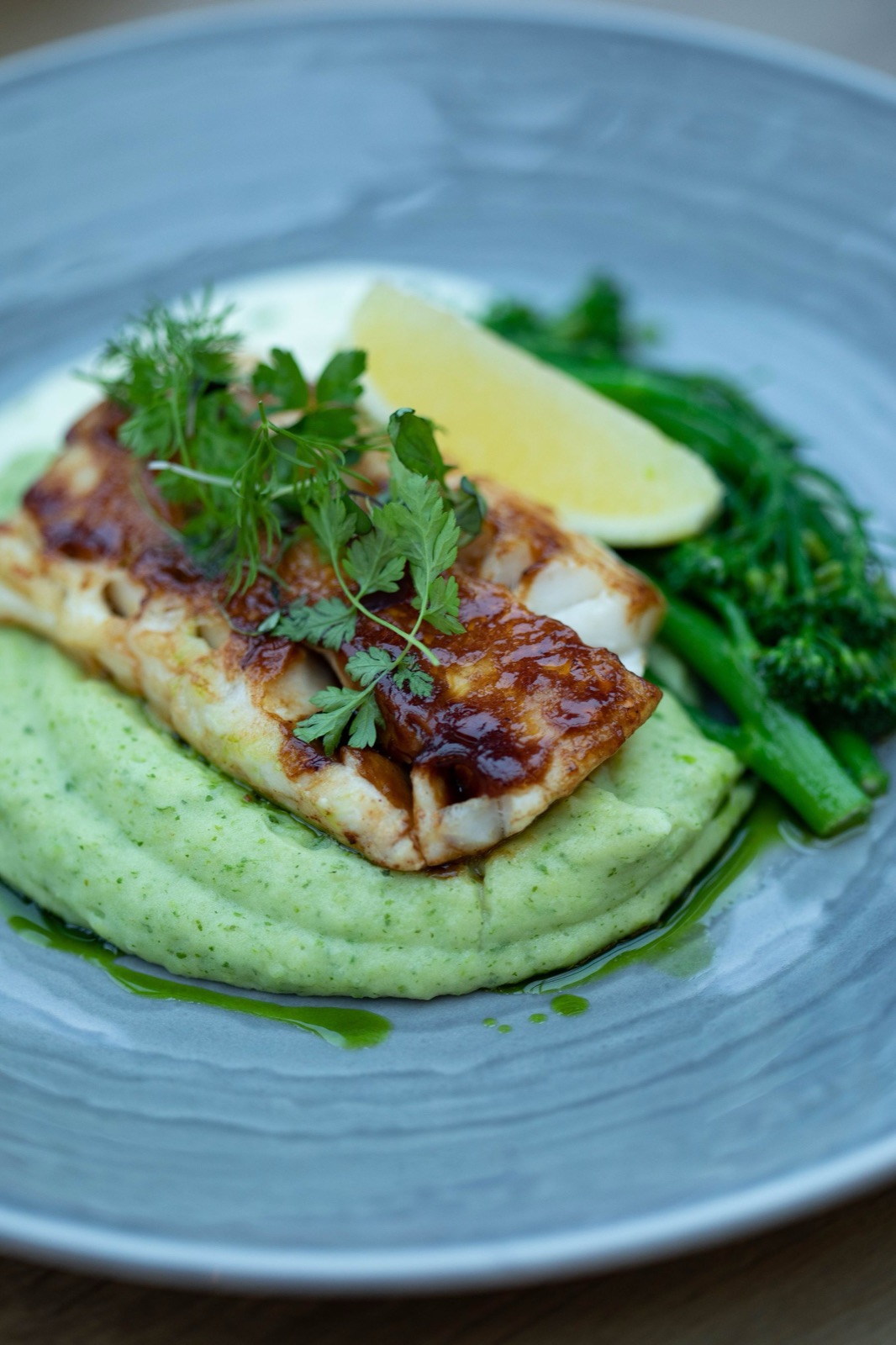 A plated fish dish with greens, used as illustrative stock photography